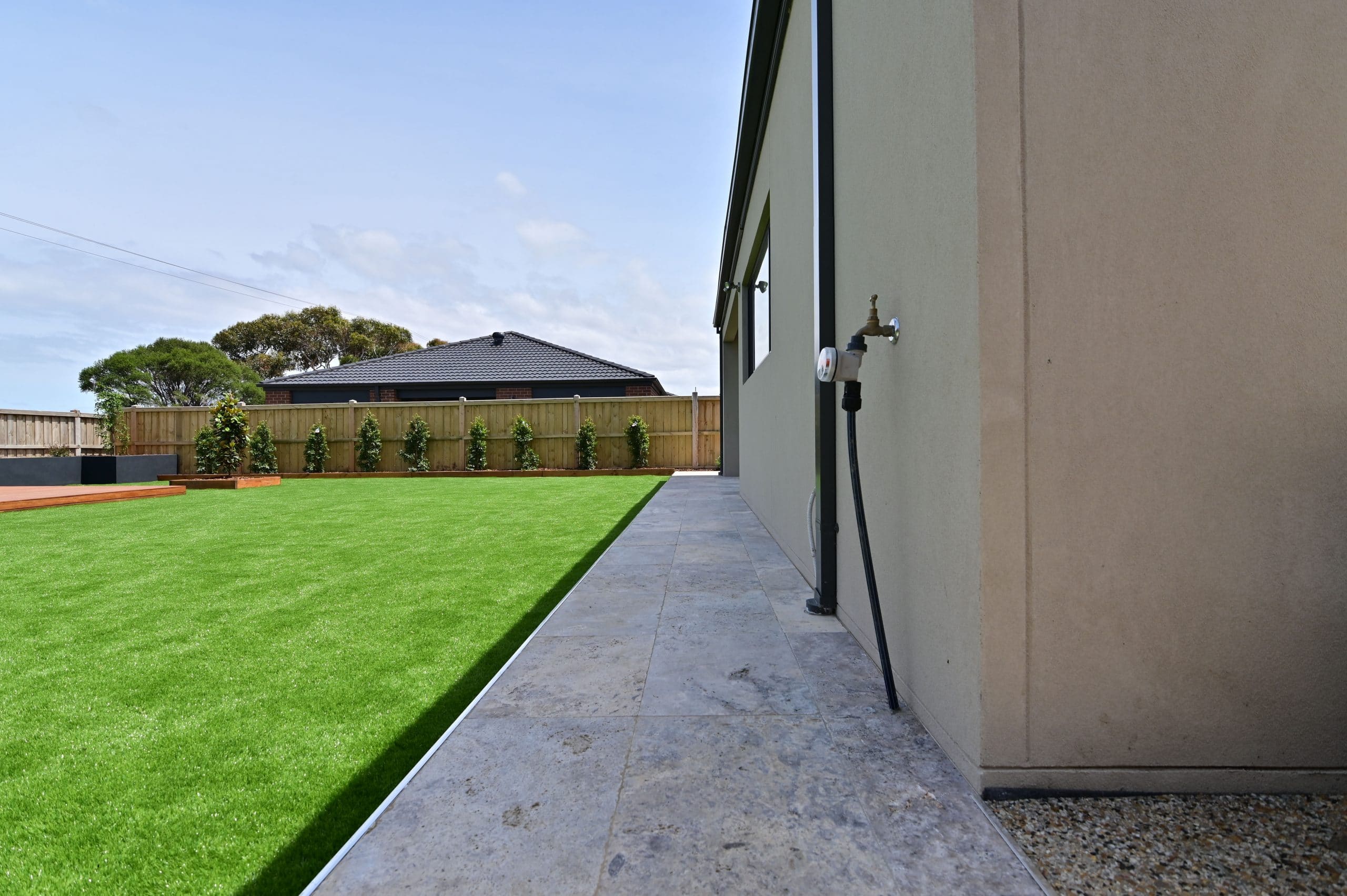 L266 - Point Cook - Backyard with grass, garden beds and a path
